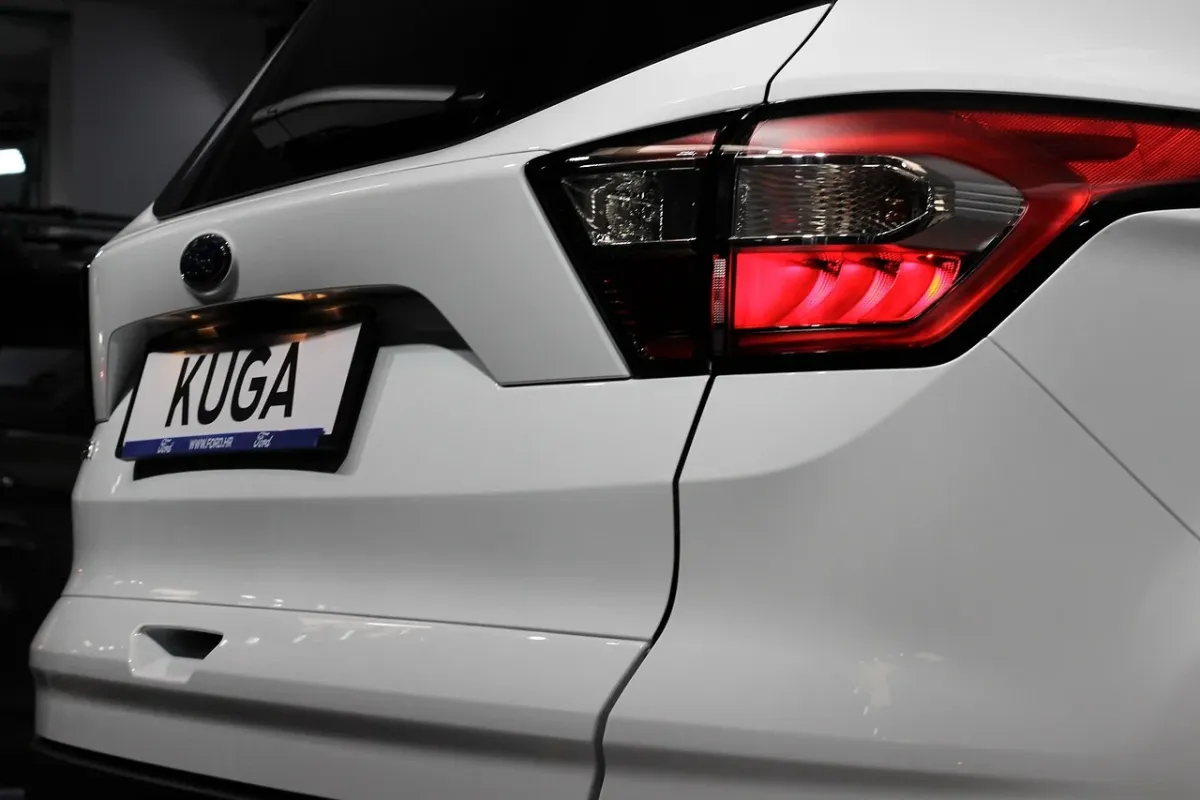Ford Kuga w wersji SUV zaparkowany na drodze, prezentujący nowoczesny design i dynamiczną sylwetkę samochodu.